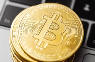 Close-up of golden Bitcoin coins stacked on a laptop keyboard showcasing cryptocurrency and finance concepts.