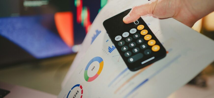 a person holding a calculator over a piece of paper