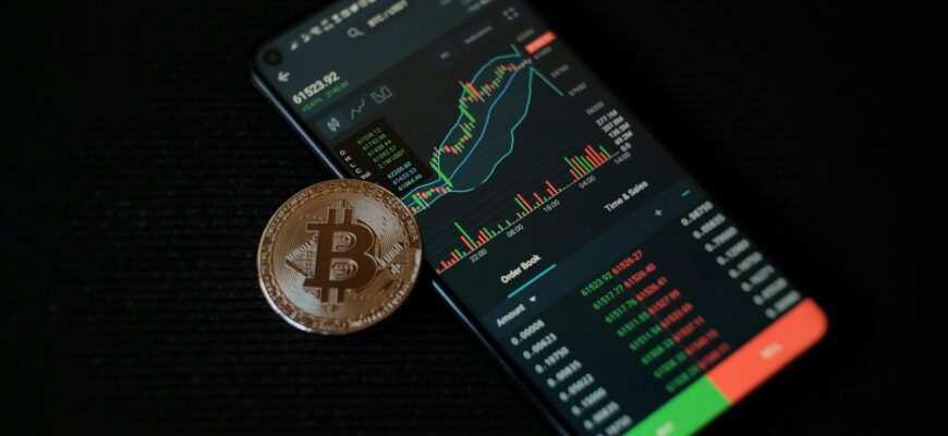 a bitcoin sitting on top of a smart phone