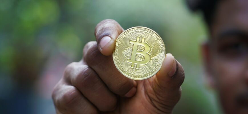 a man holding a bit coin in his hand